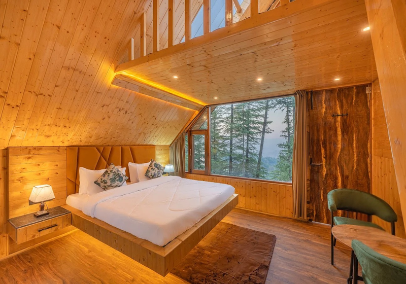 Loft bedroom with wooden beams and mountain view window